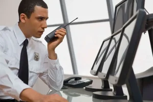 vigilanza non armata, guardia in gusrdio.la che guarda il monitor e parla alla ricetrasmittente